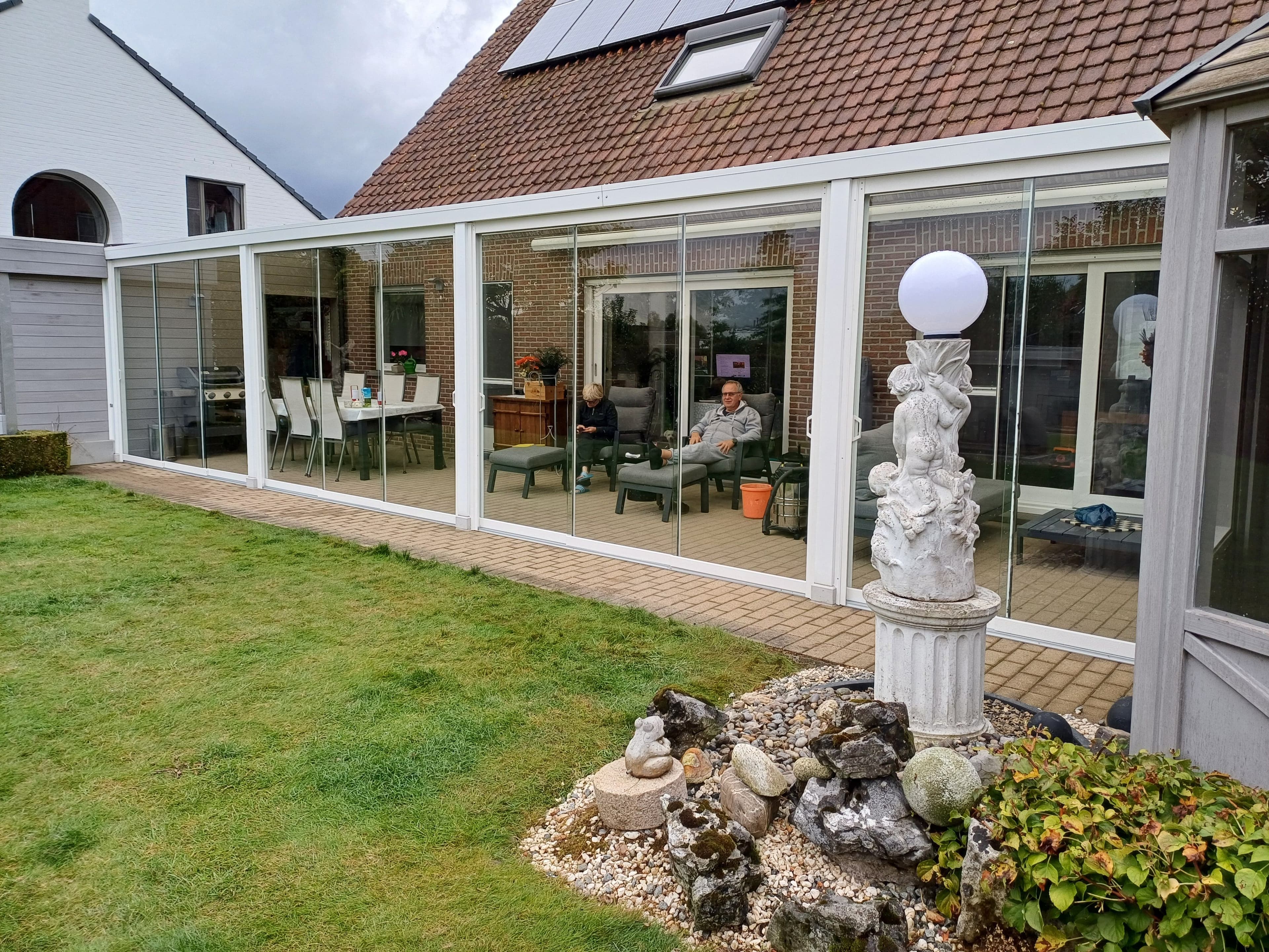 Gesloten terrasoverkapping met glazen schuifwanden en screens