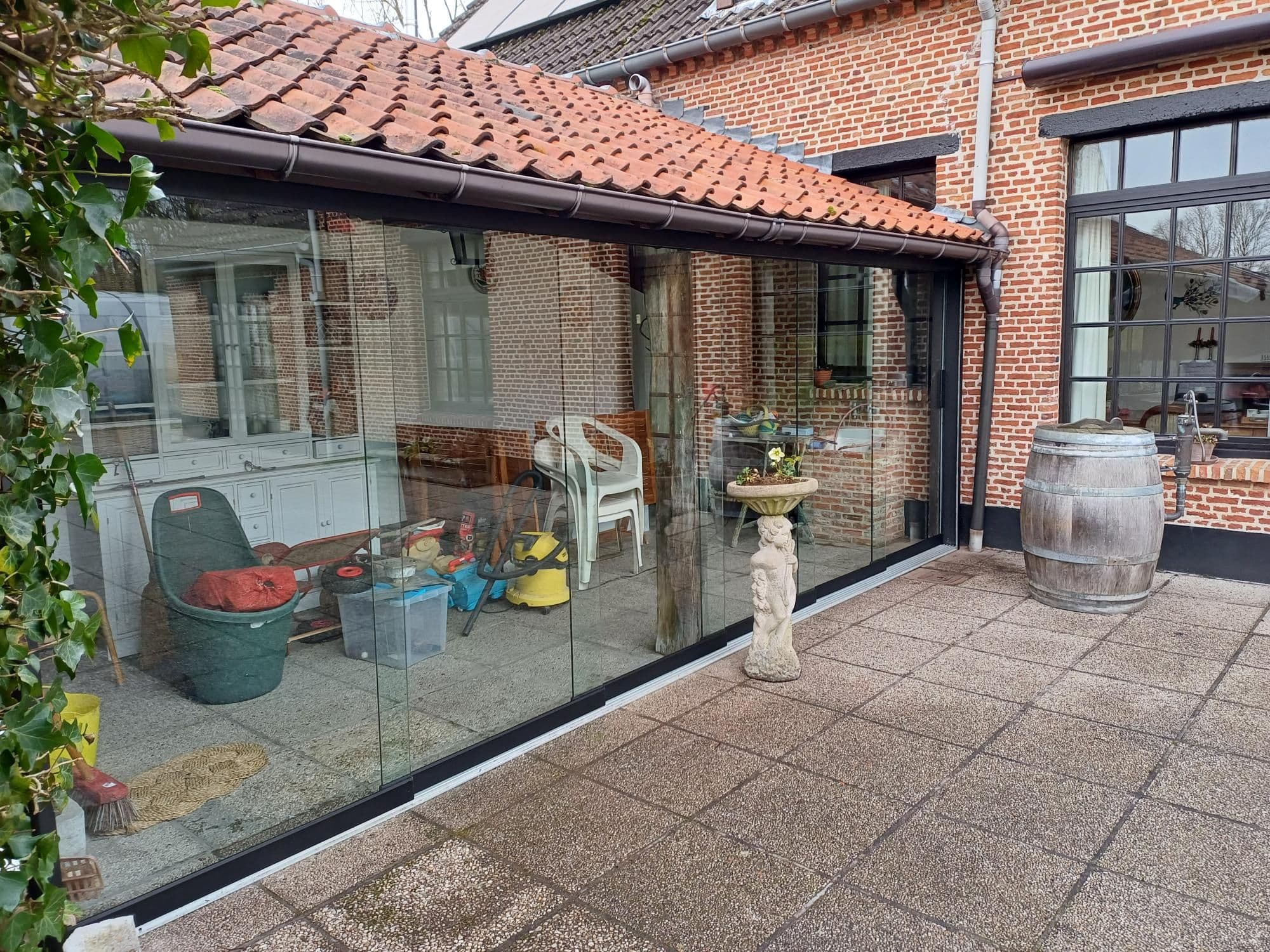 glazen schuifwanden onder afdak van een oude boerderij