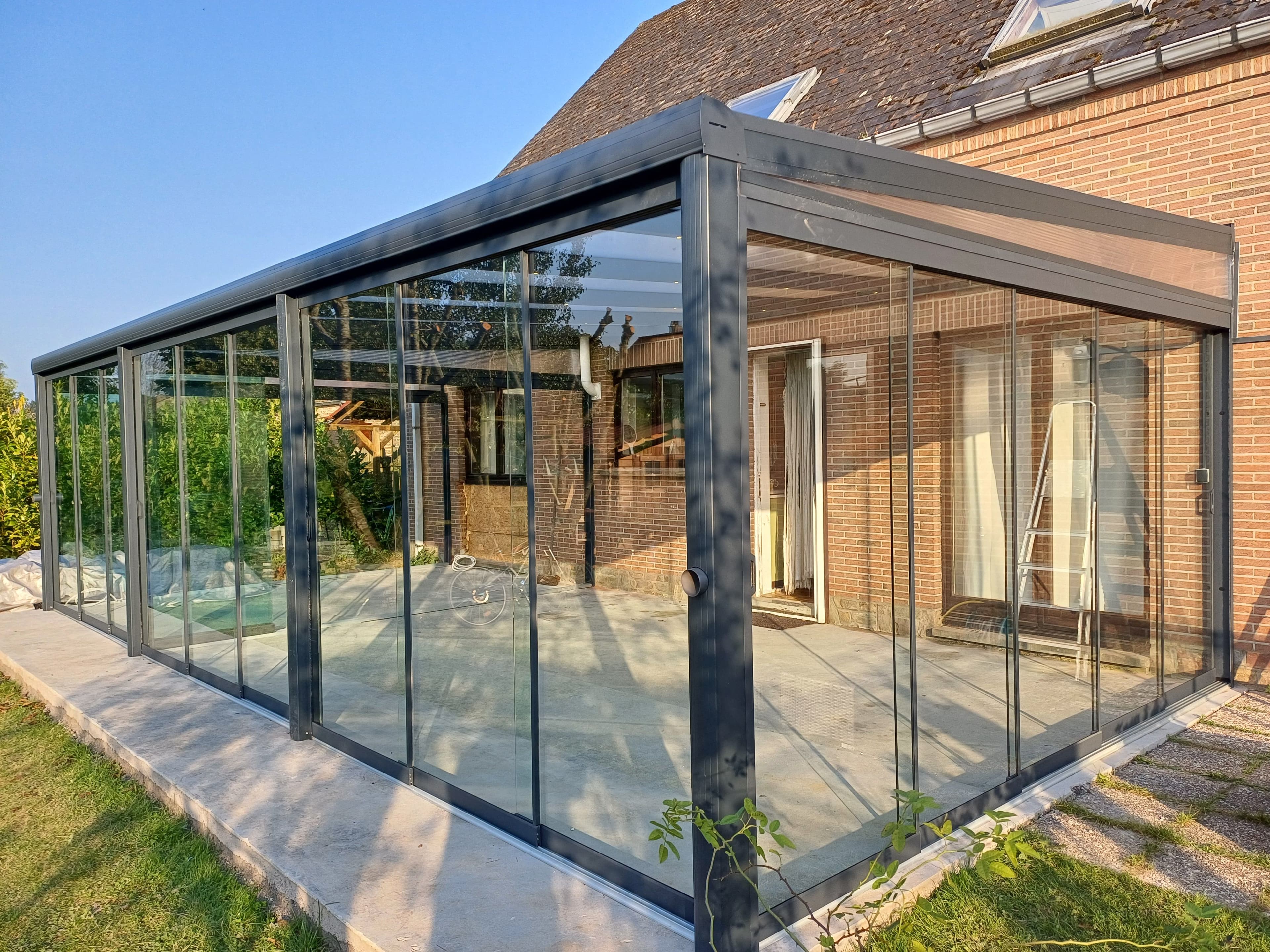 Terrasoverkapping met polycarbonaat dak en glazen schuifwanden in Beauvechain